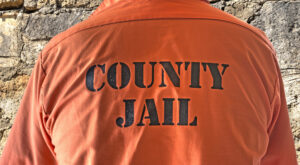jail inmate with county jail written on back of jail jumpsuit