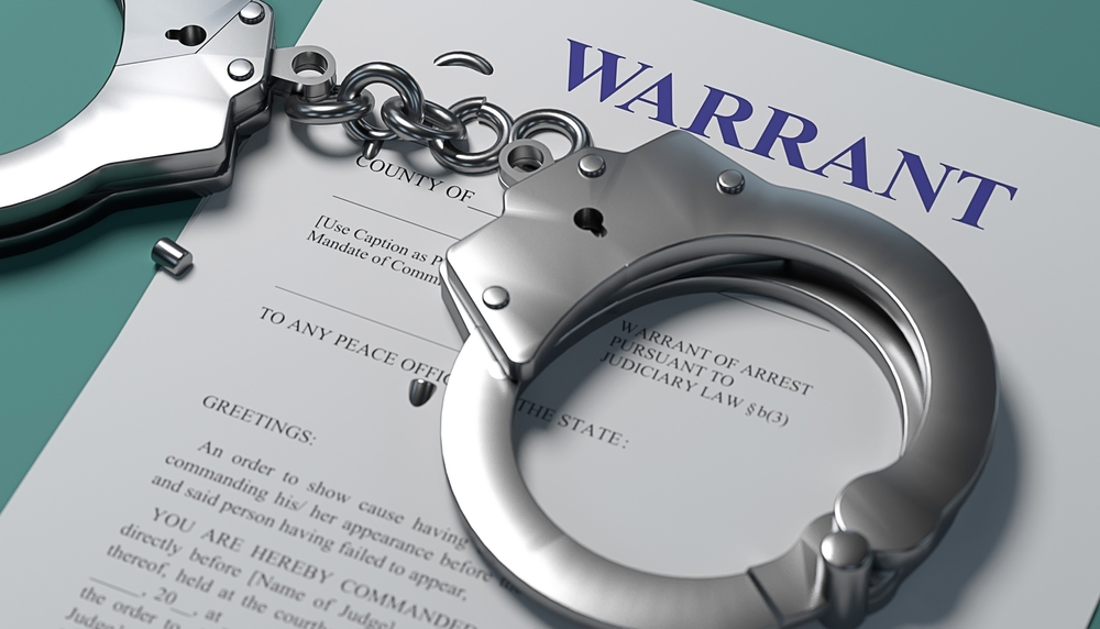 warrant paperwork and handcuffs