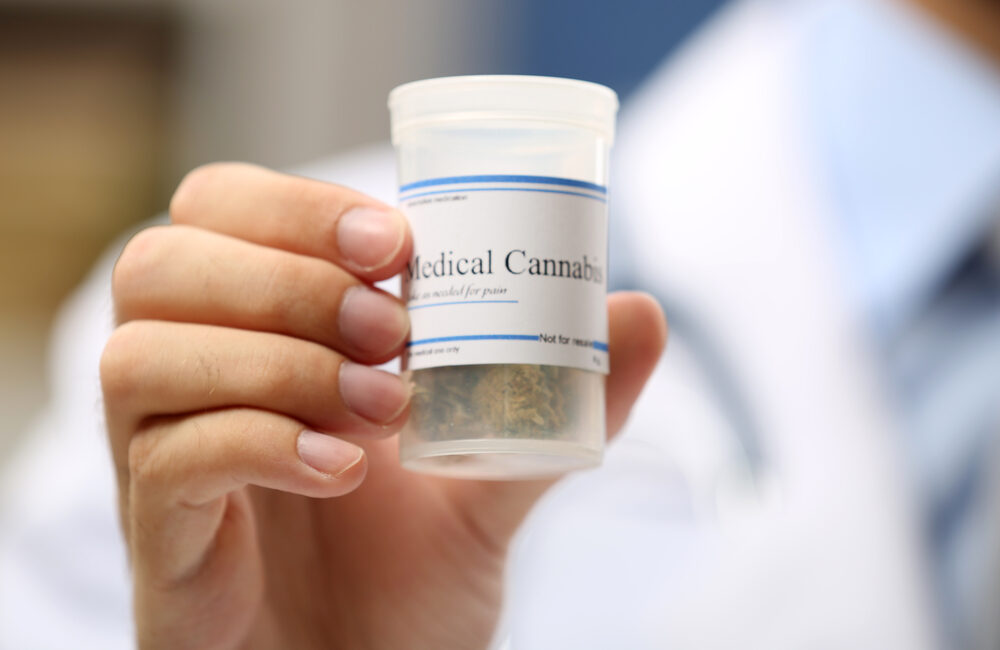 dr holding a canister of medical cannabis
