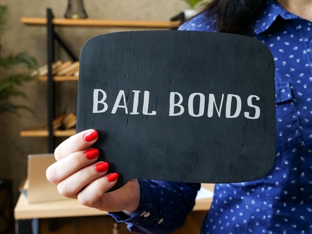 woman holding a sign that says bail bonds