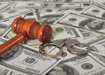 handcuffs, gavel and dollar bills